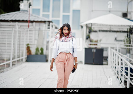 Fashion girl arabe à blouse blanche et pêche pantalon posés à l'extérieur. Élégant femme musulmane. Banque D'Images