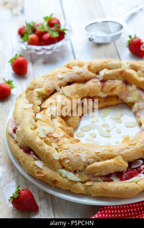 Gâteau aux fraises avec de la crème anglaise et de pâte à choux sur fond blanc Banque D'Images