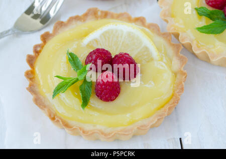 Tartelette citron curd décoré de framboise et de menthe Banque D'Images