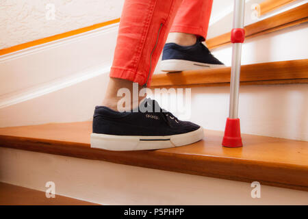 Ältere Frau geht die Treppe hinauf mit Stock, personne âgée dans les escaliers avec stick Banque D'Images