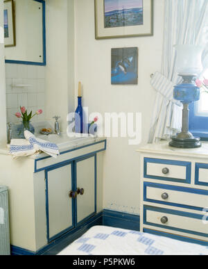 Blanc +bleu coiffeuse et la coordination d'une commode dans la petite chambre avec style Edardian brasds glasss +lampe Banque D'Images
