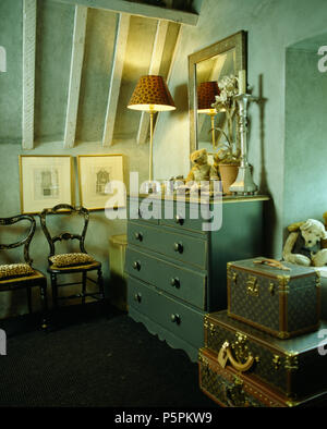 Peindre une commode et chaises anciennes en turquoise pâle chambre mansardée avec pile de valises vintage Banque D'Images