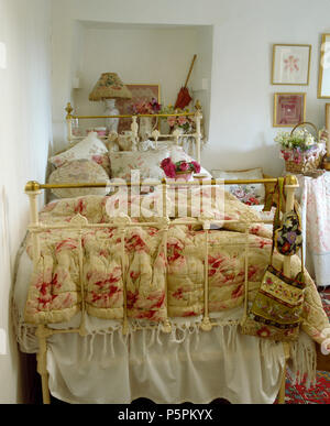 Courtepointe à motifs de roses sur blanc laiton vintage lit simple en chambre cottage Banque D'Images
