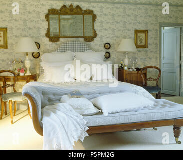Miroir antique au-dessus de lit rembourré en pays chambre avec toile blanc +bleu-de-Jouy et une chaise longue vintage Banque D'Images