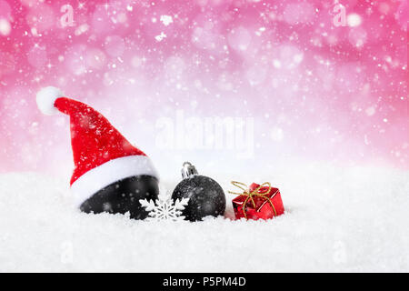 Noël arrière-plan rouge - décorées boules noires sur la neige en flocons et étoiles. Banque D'Images