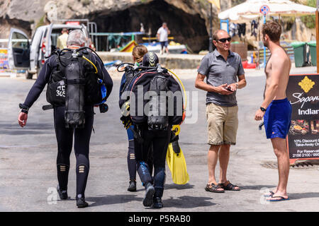 Trois plongeurs portant pleine de plongée sous-marine à pied dans une rue de Gozo, Malte Banque D'Images
