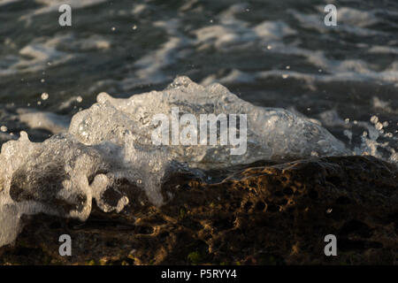 Petit splash vague sur la roche close up Banque D'Images