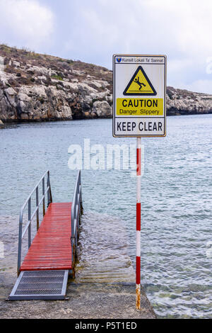 Avertissement signe que d'une jetée pouvait être glissante à Mgarr ix-Xini Banque D'Images