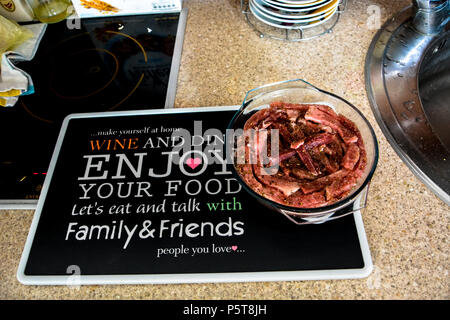 Viande de porc, de porc fines Colliers slide.Porc frais tranche servant sur le bol en verre sur tableau noir avec un(e) ami(e) message.Couper le porc avec le romarin, le poivre. Banque D'Images