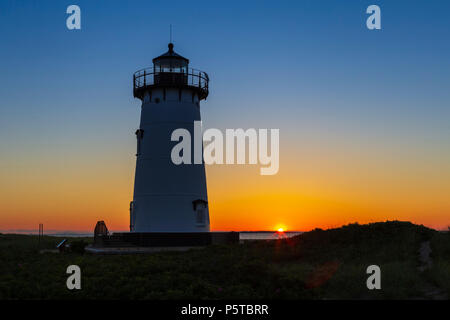 Le soleil levant donne de la couleur au ciel derrière Falmouth Harbour Light à Edgartown, Massachusetts sur Martha's Vineyard. Banque D'Images