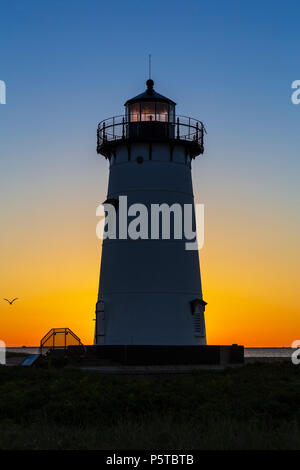 Le soleil levant donne de la couleur au ciel derrière Falmouth Harbour Light à Edgartown, Massachusetts sur Martha's Vineyard. Banque D'Images