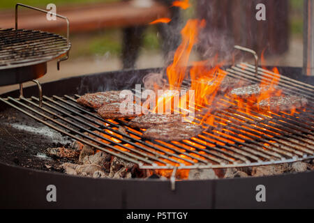 Pâtés de bœuf sur le grill sous les charbons de feu Banque D'Images