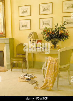 Vase de fleurs et feuillages d'été peint sur la table pour écrire en jaune pâle chambre pays Banque D'Images