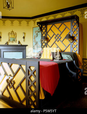 Peint à motifs géométriques et lit dans la chambre avec styleborder-gothique au pochoir de façon décorative Banque D'Images