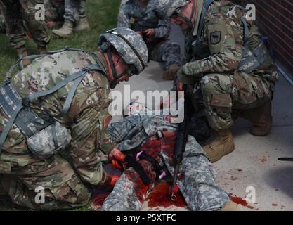 Des soldats américains avec la Garde nationale du Dakota du Sud de l'application pratique du garrot sur une victime simulée dans le cadre de la formation au Camp Ouest Lifesaver, rapide Rapid City, SD, 11 juin 2018, 11 juin 2018. L'exercice de formation de Coyote d'or est un trois-phase, axée sur des mises en exercice mené dans les Black Hills du Dakota du Sud et le Wyoming, qui permet de se concentrer sur les commandants de mission besoins essentiels concernant la tâche, les tâches et les exercices de combat guerrier. (U.S. Photo de l'armée par la FPC. James Smith). () Banque D'Images