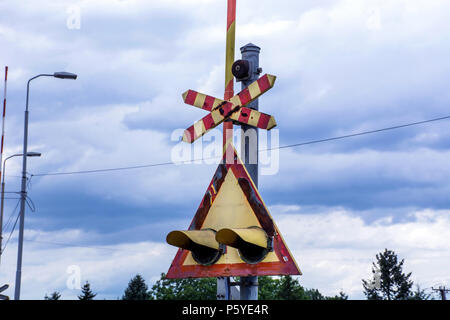 Old Railroad crossing sign lights et triangle en Serbie, l'Europe et dramatique ciel nuageux. Close up, selective focus Banque D'Images