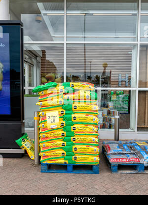 Plein de palettes de sacs de terreau à l'extérieur d'un supermarché Tesco Banque D'Images