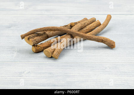 Les racines de réglisse - Glycyrrhiza glabra - sur table rustique Banque D'Images