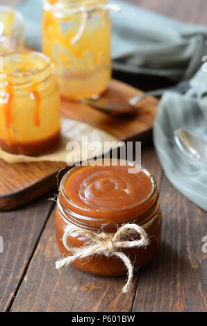 Sauce caramel maison, caramel au beurre salé sur fond de bois Banque D'Images