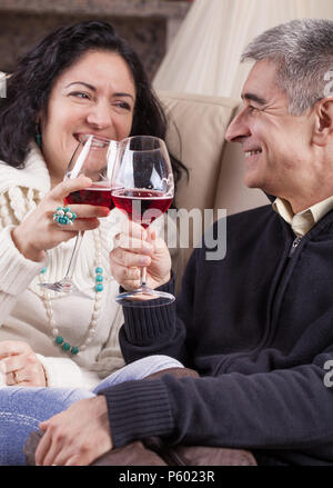 Middle aged Hispanic couple hétérosexuel détendus, boire du vin rouge. Banque D'Images