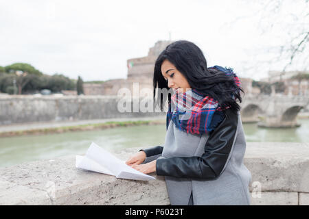 Young mixed race woman en dehors de la ville, à la carte. Banque D'Images