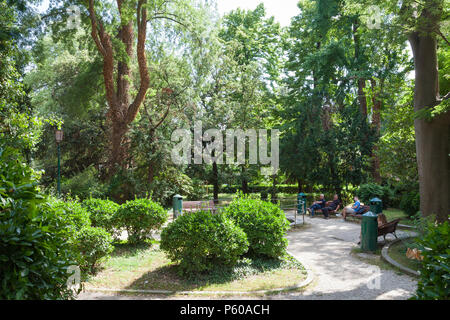 Papadopli Gardens, (Giardini Papadopoli) Santa Croce, Venise, Vénétie, Italie, les gens de détente à l'étang à l'ombre des arbres verts. Banque D'Images