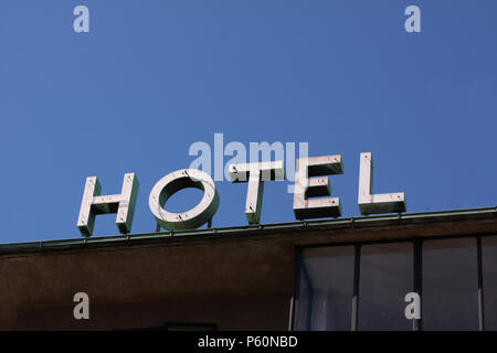Logo de l'hôtel anonyme placée sur un bâtiment contre un ciel clair blur avec copie espace pour l'écriture. Stock photo moderne et minimaliste. Banque D'Images