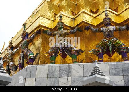 Les figurines colorées de Garuda aux bras et aux jambes tendus soutiennent une structure dorée énorme sur le terrain du Palais Royal à Bangkok, Thaïlande Banque D'Images