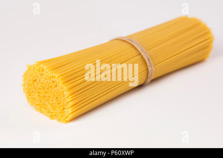 Spaghetti italien attachées avec un fil marron. Pâte de matières premières sur un arrière-plan vide Banque D'Images