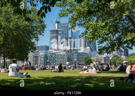 Lond, Royaume-Uni, 27 juin 2018. La canicule se poursuit dans le centre de Londres avec un ciel bleu et des températures record potentiellement. Des foules de touristes et les employés de bureau à Londres plus de place et le Tower Bridge profitant du temps chaud et du soleil assis sur l'herbe et le soleil. Crédit : Steve Hawkins Photography/Alamy Live News Banque D'Images