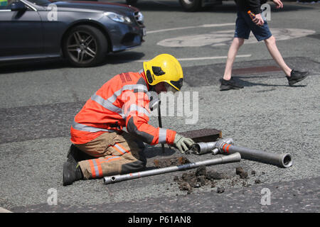 Rochdale, Lancashire, Royaume-Uni. 28 Juin, 2018. Un pompier nettoyage hors de l'eau d'une fontaine place de la route à côté de Taylor et de l'ingénierie plastique, Kingsway, Rochdale, 28 juin, 2018 Crédit : Barbara Cook/Alamy Live News Banque D'Images