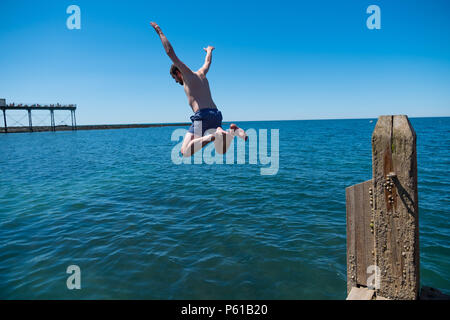 Aberystwyth, UK. 28 Juin, 2018. UK UK Weather : Sur un autre scorchingly chaude journée à la station balnéaire d'Aberystwyth, un homme passe au large de la jetée de refroidir un peu dans les eaux peu profondes de la Baie de Cardigan Le Royaume-Uni est au cœur d'une mini canicule, avec des températures qui atteignent plus de 30º Celsius dans de nombreuses régions du pays Crédit photo : Keith morris/Alamy Live News Banque D'Images