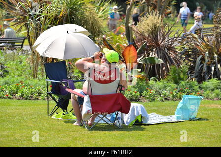 Un fan de football anglais se détend dans un transat en buvant une bière Le soleil dans un parc pendant la coupe du monde 2018 Banque D'Images