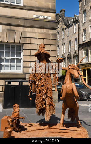 L'assistant de lévitation habillé en serpents et lézards street performer sur Lawnmarket sur le Royal Mile Edinburgh Scotland UK Banque D'Images