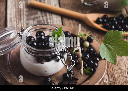 Cheesecake creme de cassis frais avec les parfaits dans le jar de l'été, de délicieux desserts sans cuisson sur table en bois rustique prêt à manger Banque D'Images