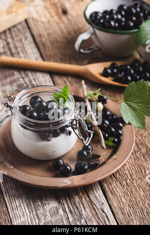 Cheesecake creme de cassis frais avec les parfaits dans le jar de l'été, de délicieux desserts sans cuisson sur table en bois rustique prêt à manger Banque D'Images