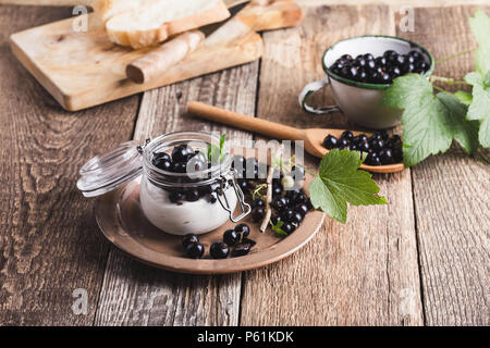 Cheesecake creme de cassis frais avec les parfaits dans le jar de l'été, de délicieux desserts sans cuisson sur table en bois rustique prêt à manger Banque D'Images