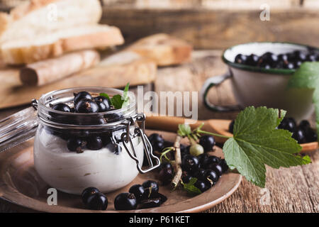 Cheesecake creme de cassis frais avec les parfaits dans le jar de l'été, de délicieux desserts sans cuisson sur table en bois rustique prêt à manger Banque D'Images