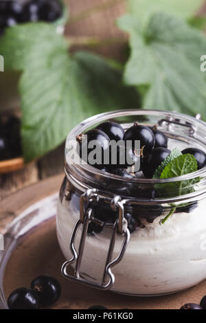 Cheesecake creme de cassis frais avec les parfaits dans le jar de l'été, de délicieux desserts sans cuisson sur table en bois rustique prêt à manger Banque D'Images