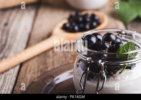 Cheesecake creme de cassis frais avec les parfaits dans le jar de l'été, de délicieux desserts sans cuisson sur table en bois rustique prêt à manger Banque D'Images