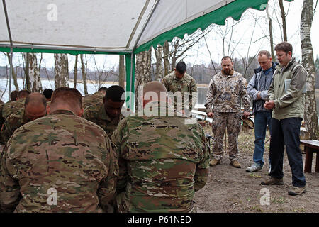 Stephen Janz (à droite), un missionnaire et camp de développeur de Calgary, au Canada, donne la bénédiction avant le déjeuner pour les soldats affectés au siège des troupes et de l'Administration centrale, 3e Escadron, 2e régiment de cavalerie, qui a passé la matinée à préparer un camp de jeunes chrétiens pour l'été, le 9 avril, à Daugavpils, Lettonie. Janz, un ami du Capitaine Ruslans Markevics (troisième à partir de la droite), le 2e Bataillon d'infanterie, de l'aumônier de l'armée lettone, passé du temps avec des soldats tout en aidant à éliminer un sentier et d'autres tâches nécessaires pour obtenir le camp prêt à l'emploi dans les mois à venir. (U.S. Photo de l'armée par le Sgt. Paige Banque D'Images