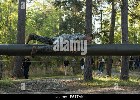 Des soldats de l'armée américaine ont participé au Darby Queen obstacle course à Fort Benning, en Géorgie, le 17 avril 2016, lors de la 33e édition annuelle de David E. Grange Jr. Meilleur concours de Ranger. L'événement a testé la forme physique, l'endurance mentale et les compétences techniques à travers des obstacles tels que le Belly Buster. Les concurrents ont été évalués sur la manœuvre, la vitesse, l'agilité et la prise de décision tactique. Les unités impliquées comprenaient le 7e Groupe de forces spéciales et la Brigade d'entraînement aéroportée et des Rangers, démontrant les capacités des soldats d'élite et la compétence en matière d'entraînement. Banque D'Images