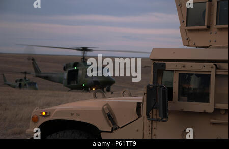 Les forces de sécurité de défenseurs du 90ème Groupe des forces de sécurité surveillent comme deux 37e Escadron d'Hélicoptères Bell UH-1N hors ralenti un site de lancement le 14 avril 2016, au cours d'un exercice de la F.E. Warren Air Force Base, Wyo., complexe de missiles. La 90e Escadre de la Force aérienne et antimissile Global Strike Command mener les opérations et exercices de formation sur une base régulière afin de s'assurer forces canadiennes sont prêtes à effectuer des opérations d'intervention. (U.S. Photo de l'Armée de l'air par la Haute Airman Brandon Valle) Banque D'Images