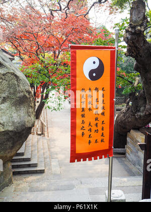 QIngdao, Chine - Décembre 2017 : orange dynamique avec drapeau taoïste Yin Yang symbole dans la cour principale du Temple Taiqing sur Circuit Banque D'Images