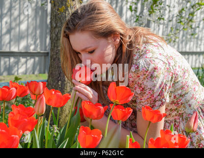 L'inhalation de fille de tulipes. La jeune fille parmi les fleurs. Banque D'Images