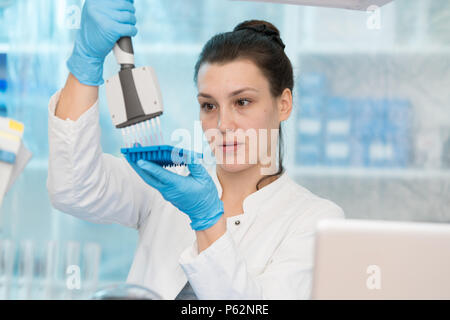 Jeune femme à la recherche génétique dans le laboratoire de recherche sur les maladies du cancer Banque D'Images