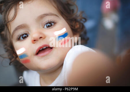 Kid avec ventilateur blanc bleu et drapeau rouge peint sur le visage Banque D'Images