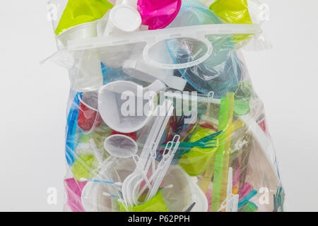 Sac poubelle rempli de vaisselle jetable, des ustensiles en plastique, verres en plastique, des sacs en plastique et autres déchets en plastique, de différentes couleurs, tailles et types Banque D'Images