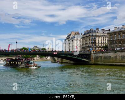 Bateau de tourisme en passant sous un pont où des foules de gens participent à une célébration de la Journée olympique, Paris, France Banque D'Images