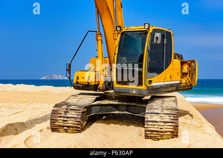 Cabine pelle jaune et le bras sur le sable à plage dans une journée ensoleillée Banque D'Images